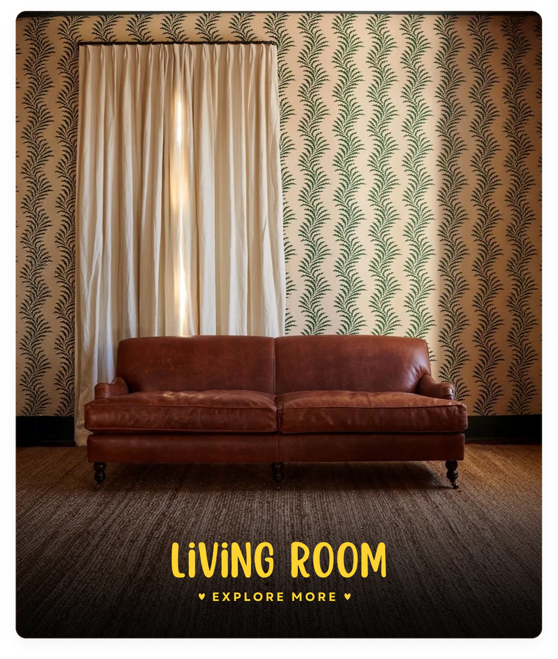 Brown leather sofa in a living room with patterned wallpaper and curtains.