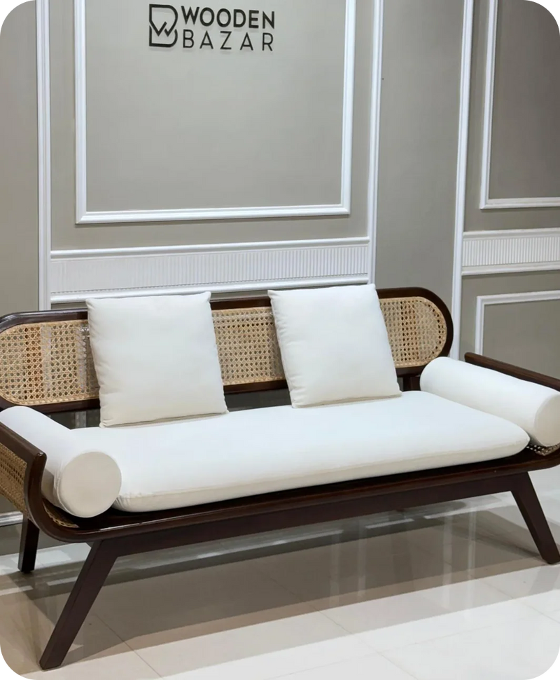 Sofa with white cushions against a gray wall 